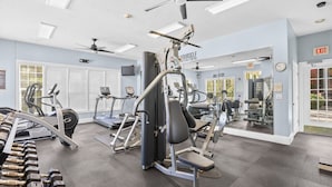 Un gimnasio con cintas de correr, máquinas de pesas y mancuernas.