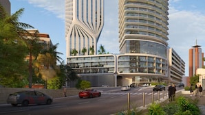 Un hotel moderno con un diseño curvo único, que cuenta con múltiples balcones y una estructura vertical destacada.