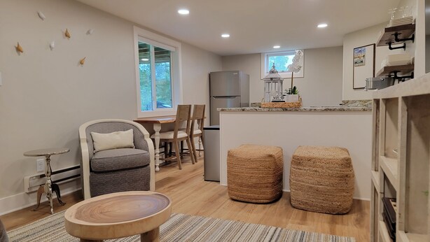 Eine moderne Küche mit Essbereich, Holzstühlen, einer Couch und einem kleinen Tisch.