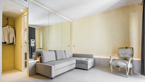 A modern room with a grey sectional sofa, a white armchair, and a mirror reflecting the room. - Casa Novella con Terrazza by Wonderful Italy (Noto)