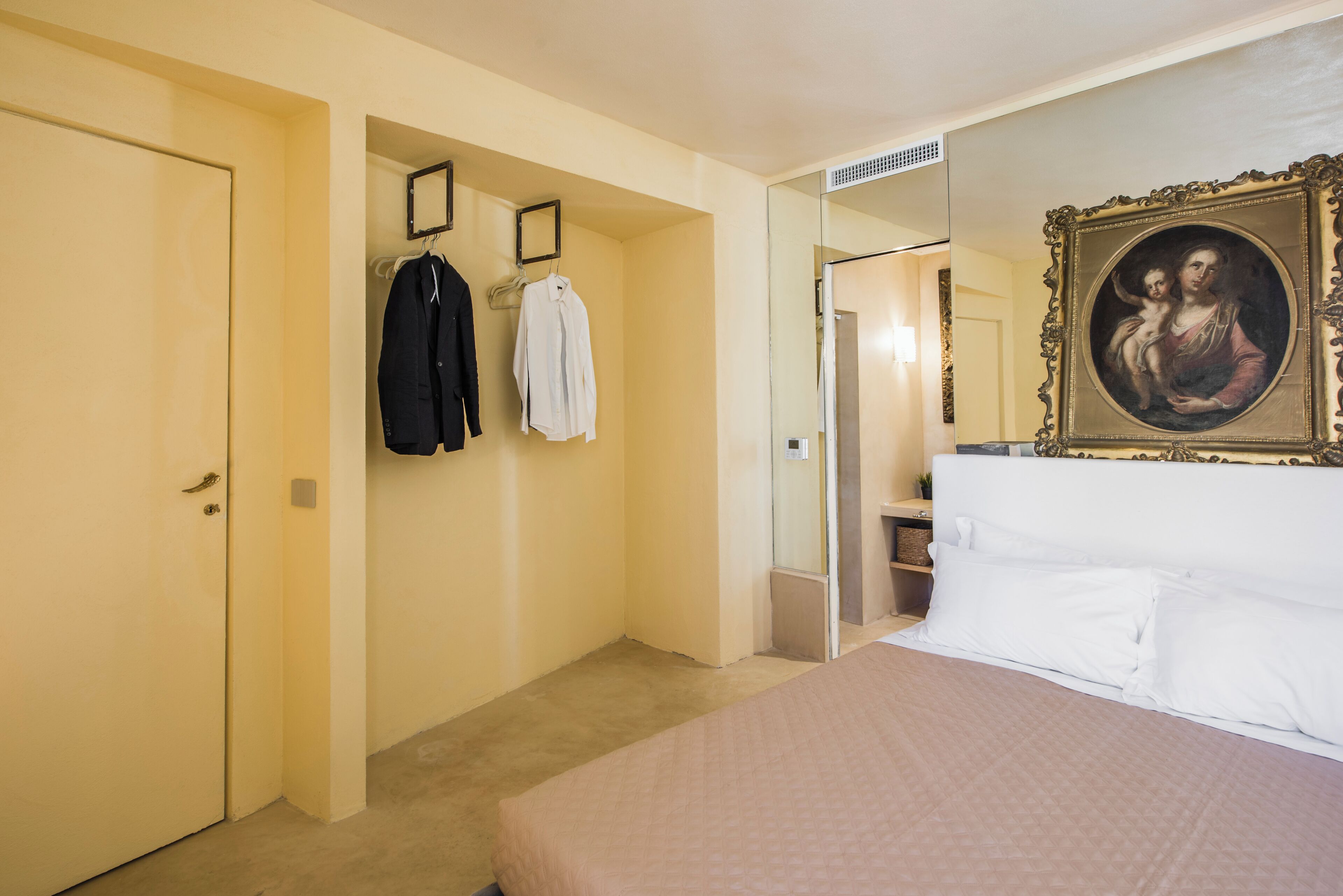 Une chambre d’hôtel avec un lit, une armoire et un miroir.
