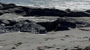 Una playa rocosa con olas rompiendo en la orilla.