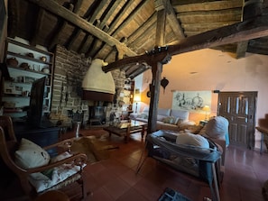 A rustic interior with a stone fireplace, wooden furniture, and a hammock. - Country House 'Villa Rural El Molino Blanco' with Mountain View, Wi-Fi and Air Conditioning (Sotillo Del Rincon)