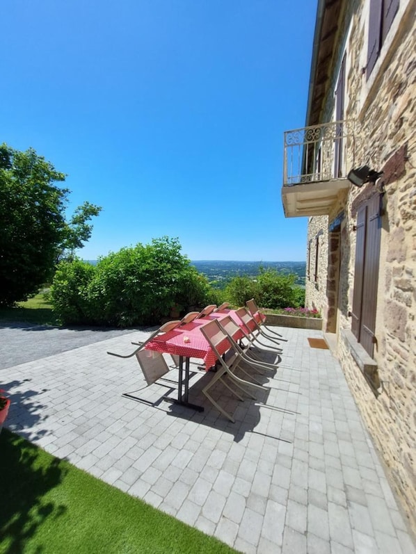Un patio con mobiliario exterior y vistas al campo.