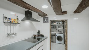 A kitchen with a built-in dishwasher, a coffee machine, and a hanging utensil rack. - Casa La Molina – Spacious Countryside Home with Mountain Views near Burgos (Burgos)