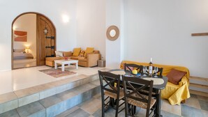 Uma sala de estar moderna com sofá, mesa de centro e mesa de jantar posta para refeição.