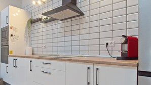 A modern kitchen with white cabinets, a wooden countertop, a red coffee machine, and a tiled backsplash. - Country House Near Arribes del Duero - Sardón de los Frailes, Salamanca (Sardón de los frailes)