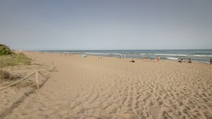 A sandy beach with footprints, a wooden fence, and the ocean in the background. - Apartment 'Bonito Apartamento En Gava Mar' with Private Terrace, Wi-Fi and Air Conditioning (Gavà)