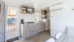 Une cuisine compacte équipée d’une cuisinière à gaz, d’un four à micro-ondes et d’un four encastré.