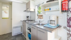 Eine moderne Küche mit Gasherd, Spüle und Kaffeemaschine.