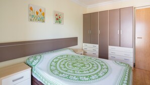 A bedroom with a bed, a wardrobe, and two wall-mounted paintings. - Apartment 'La Paz De Xinxilla' with Sea Views, Wi-Fi and Air Conditioning (Dénia)