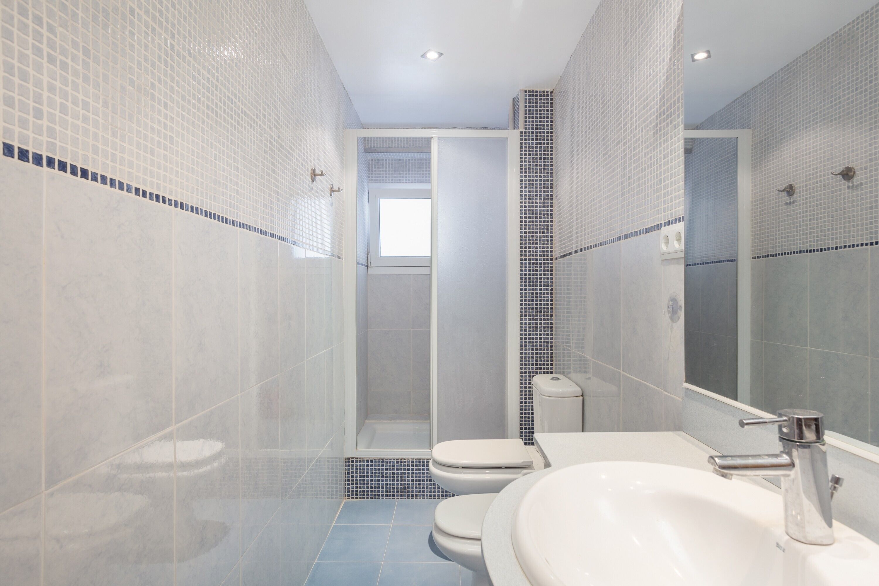 A bathroom with a shower, toilet, and sink.