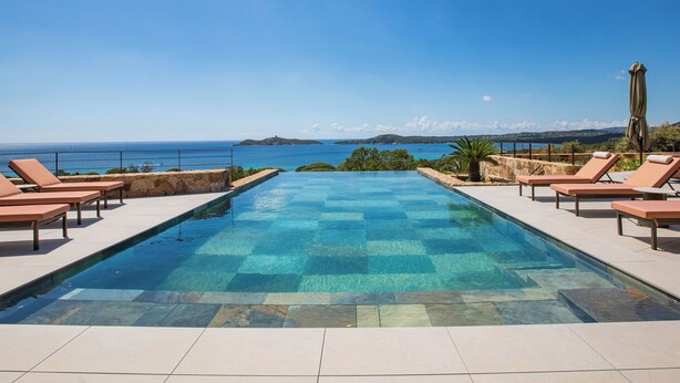 A swimming pool with lounge chairs and a view of the sea. - Villa Lucia Di Arinella (Zonza)