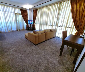 Family Suite, City View | Ruang tamu | 36 inci televisyen LCD dengan saluran TV premium, pendiangan 