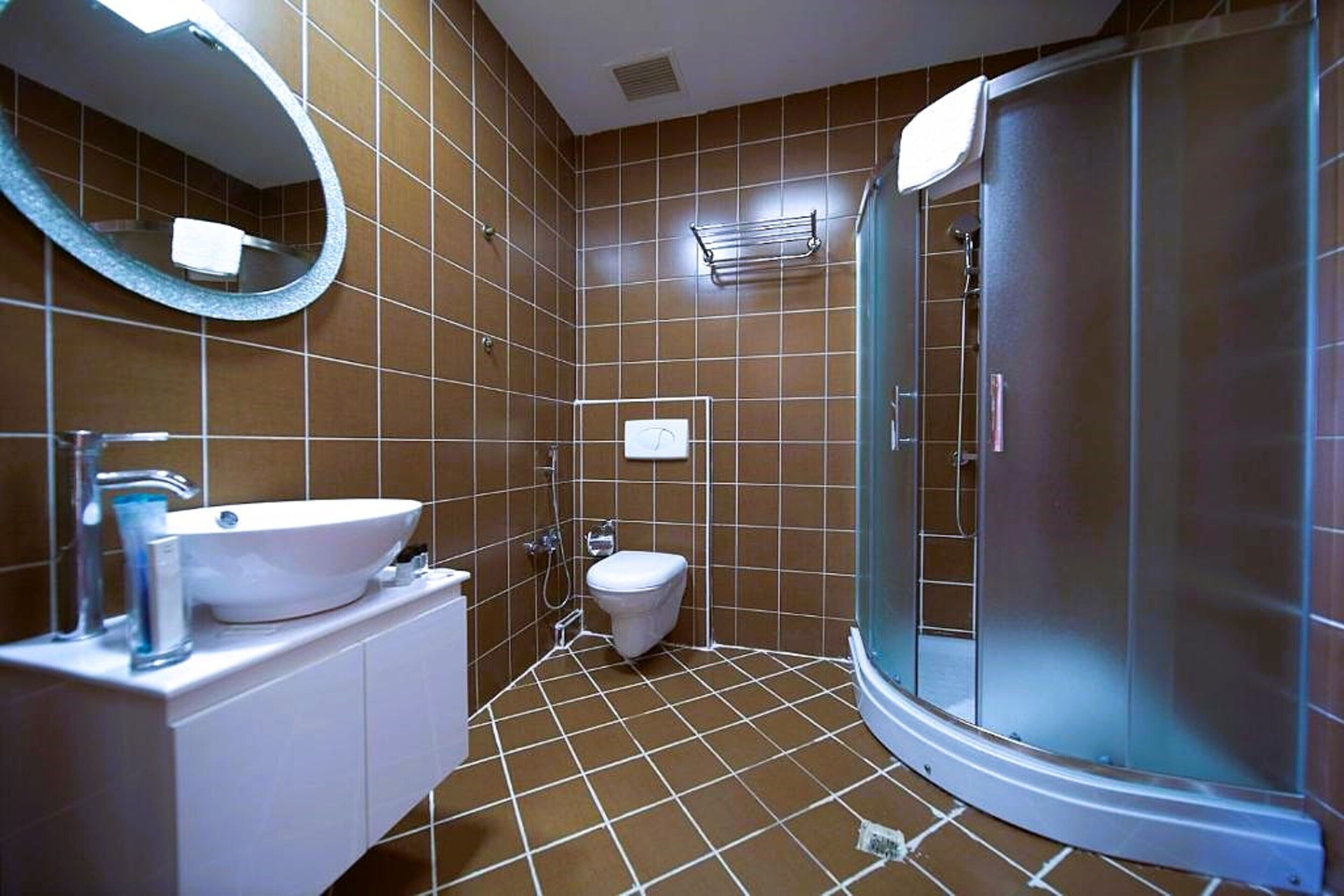 A bathroom with a white sink, a toilet, and a glass-enclosed shower.
