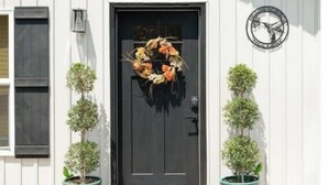 A building with a black door, a wreath, and two potted plants. - Hummingbird Hideaway- private self-check -Wi-Fi (Murfreesboro)