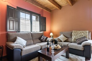 A living room with two sofas, a coffee table, a wine bottle, and a glass.