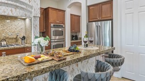 A kitchen with granite countertops, stainless steel appliances, and wooden cabinets. - Walk to Stagecoach,incredible gameroom, putting green, bocce, slide, pickleball (Indio)