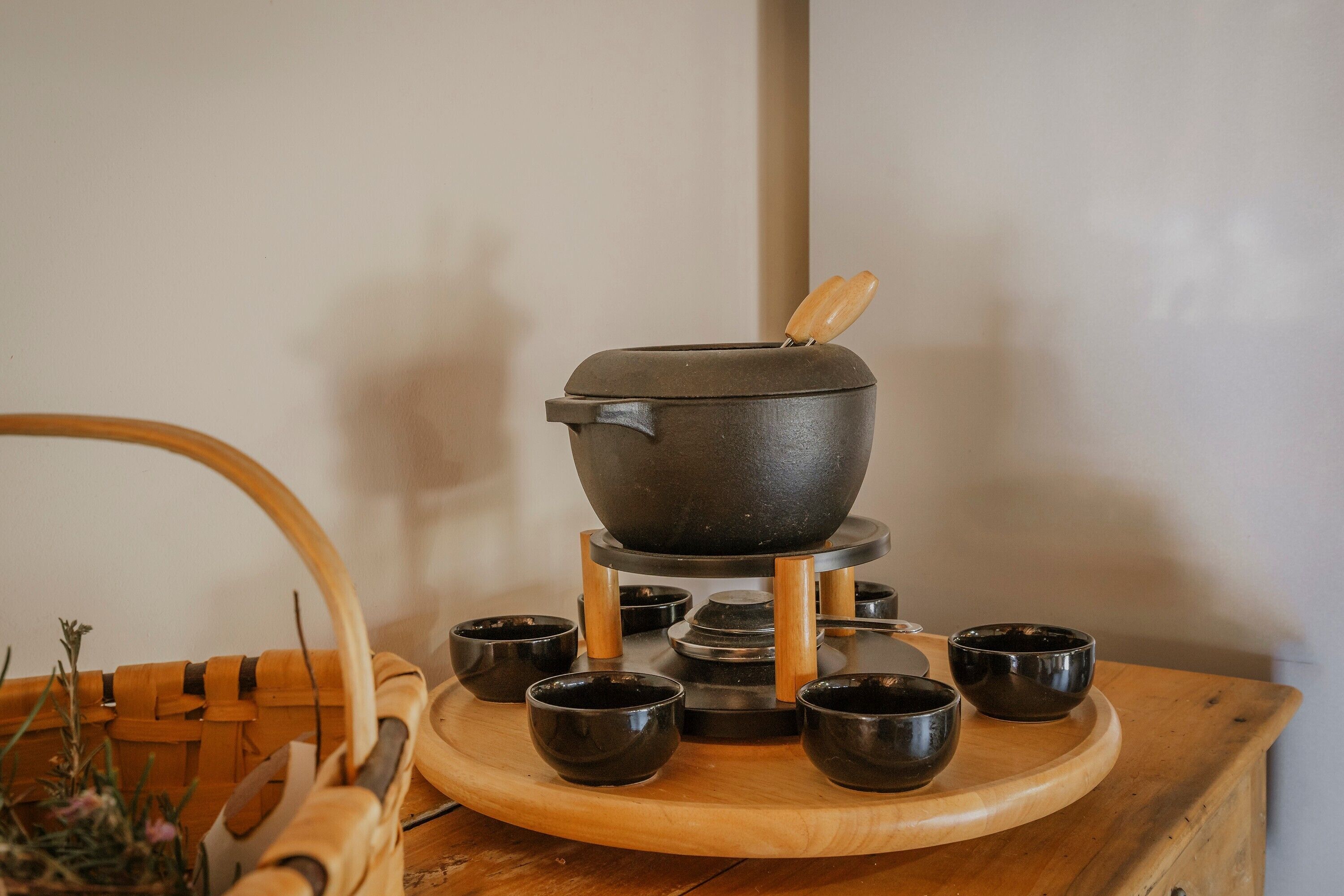 Un service à thé japonais traditionnel, composé d’une théière noire et de six tasses, présenté sur un plateau en bois.