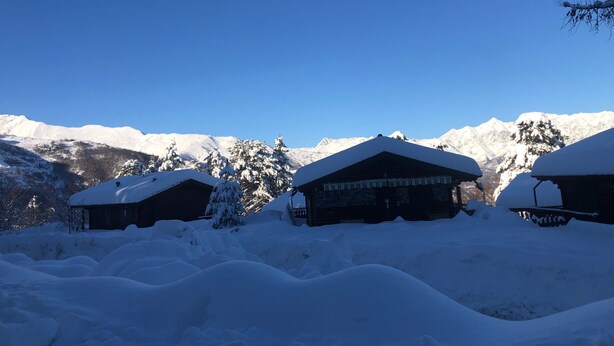 Un paysage de montagne enneigé, avec des chalets en bois.