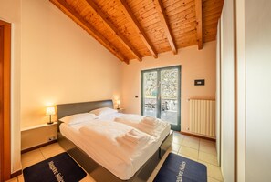 A hotel room with a bed, bedside lamps, a window, and a view of the outdoors.