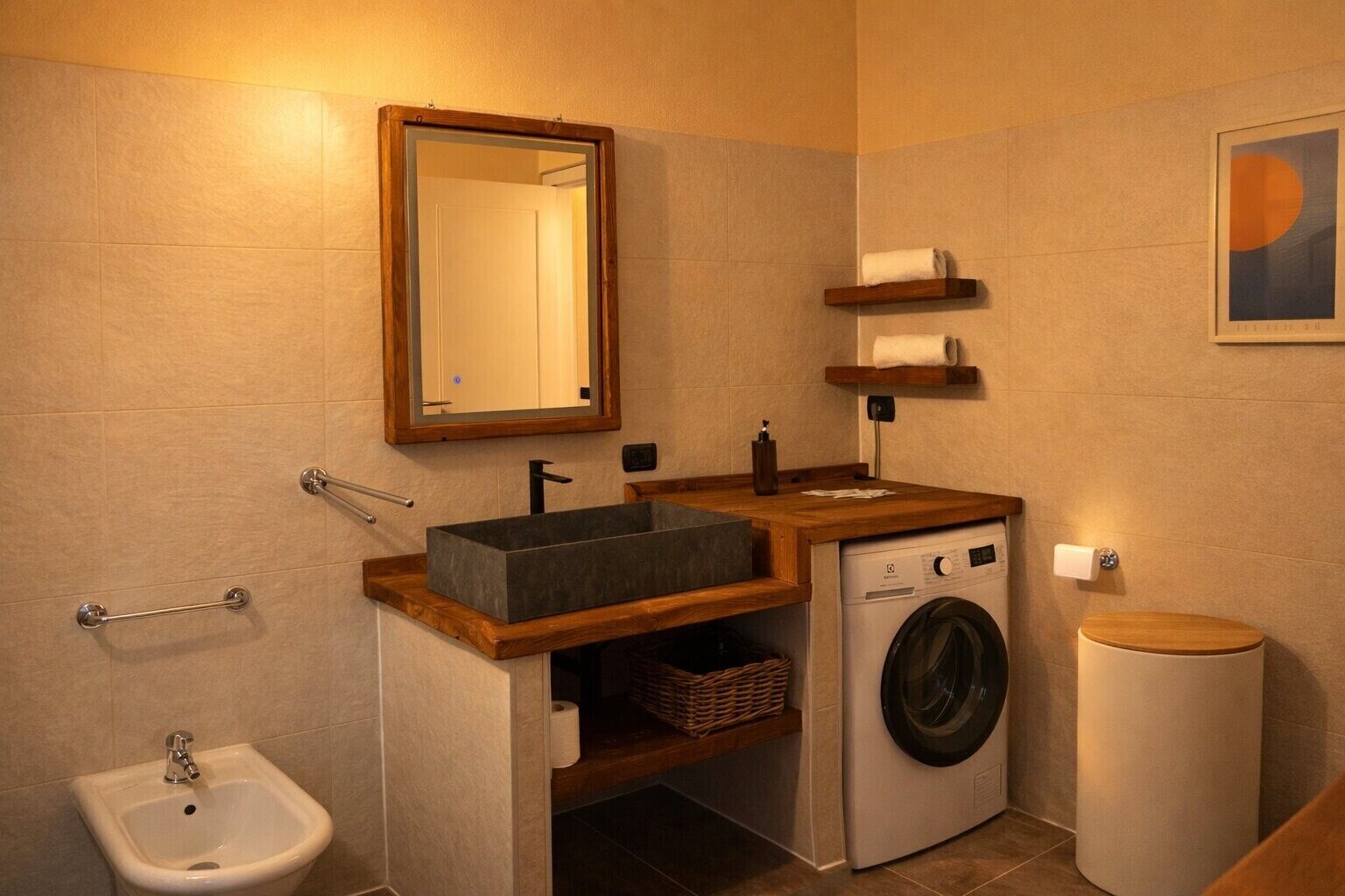 A compact bathroom with a sink, mirror, bidet, toilet, and washing machine.