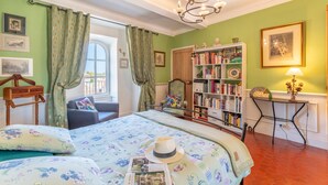 A bedroom with a bed, a bookshelf, a desk, and a chair.