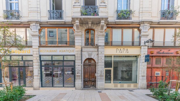 A building facade with a restaurant, a Papa's Pizza, and a storefront.
