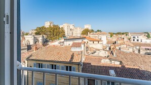 A view of a historic cityscape with traditional architecture and a prominent castle in the background.