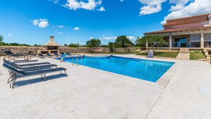 A swimming pool with lounge chairs, a stone barbecue, and a stone wall. - Amazing home in Gornje Rastane (Gornje Rastane)