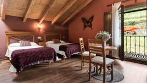 Ein Schlafzimmer mit zwei Betten, einer Holzbalkendecke, einem Fenster mit Ausblick nach draußen und einem Tisch mit einem Stuhl.