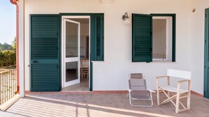 A balcony with a chair, a table, and a door leading to a room. - Apartment 'Muma 4' with Shared Terrace, Wi-Fi and Air Conditioning (otranto)