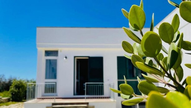 A modern building with a flat roof, large windows, and a visible door. - Apartment 'Muma 4' with Shared Terrace, Wi-Fi and Air Conditioning (otranto)