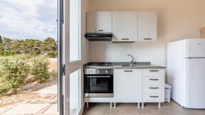 A modern kitchen with white cabinets, a built-in oven, a gas stove, and a refrigerator.
