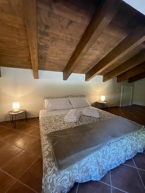 Une chambre à coucher avec un lit, deux tables de chevet et un plafond en bois.