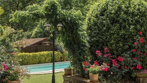 A garden with a pool, surrounded by lush greenery and flowering plants. - Holiday Home 'Cascina Oddone Prati Winery' with Shared Pool, Wi-Fi and Air Conditioning (Strevi)