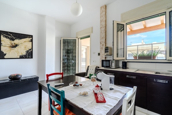 Una cocina moderna con comedor, un amplio ventanal con vistas y un microondas.
