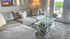 A living room with a sofa, a glass coffee table, and a rug. - “The Disney Diamond Bungalow” (Kissimmee)