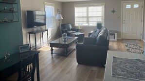 A living room with a sofa, a coffee table, a TV, and a lamp. - Wells Charmer 2 Bed close to Wells Beach, Restaurants, AC, WiFi. 
Sleeps 6, Deck (Wells)