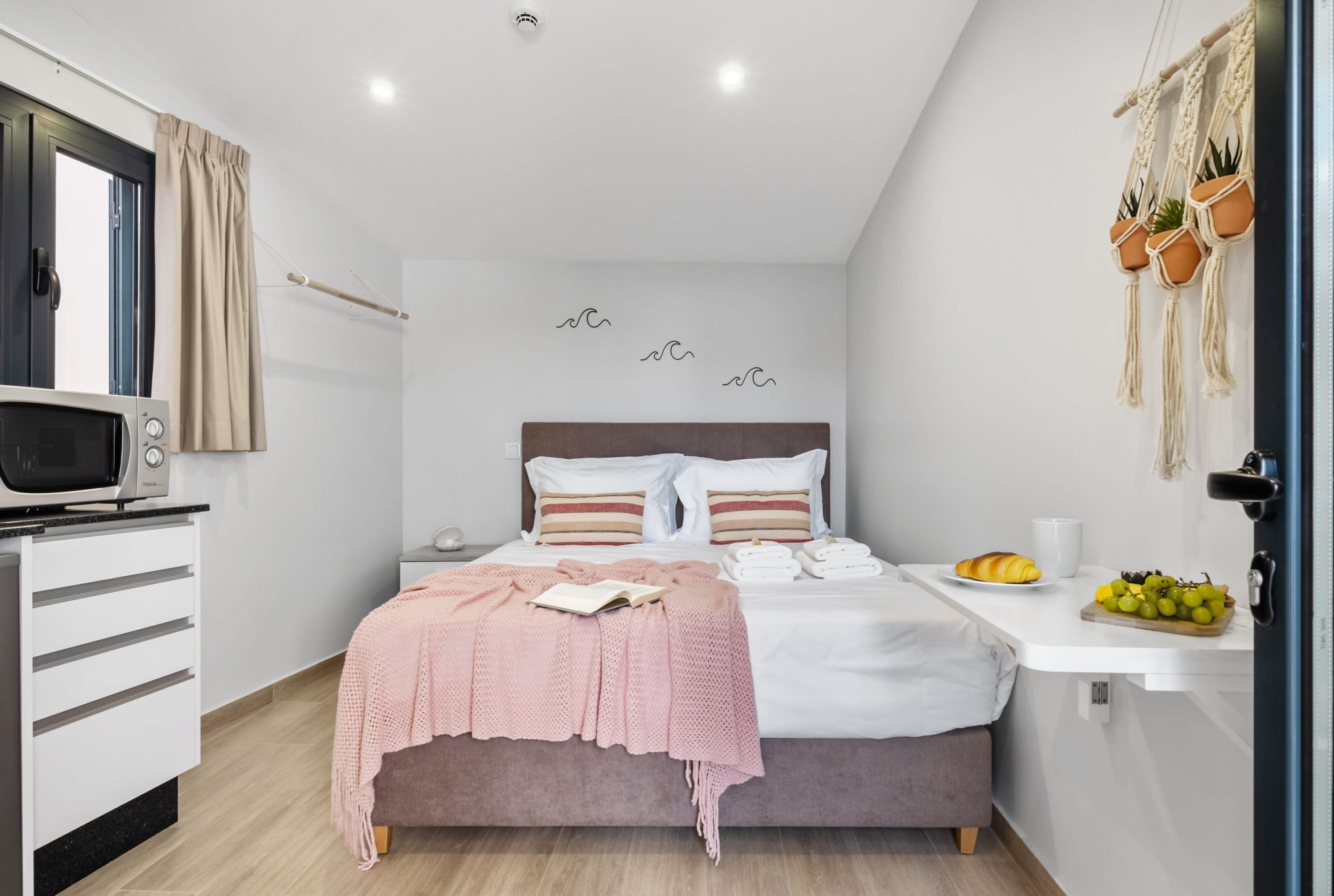 Une chambre moderne avec un lit, une table de chevet et un four à micro-ondes.
