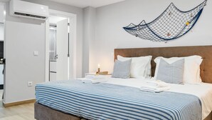 A modern hotel room with a large bed, a wooden headboard, and a wall-mounted hammock. - Seaside Sunset - Fisherman s House by Homie (Calheta)