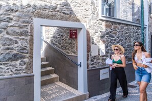 Un bâtiment en pierre avec un escalier menant à une porte portant l’inscription « 5ª Vareda da Igreja ».
