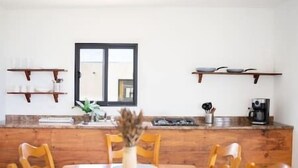 Comedor con sillas de madera, una mesa redonda y ventana con vistas.