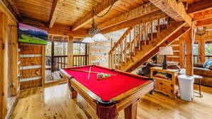 A wooden interior with a pool table, a staircase, and a television mounted on the wall. - Stairway to Heaven •Breathtaking Mountain Views• (Sevierville)