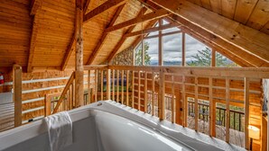 A wooden cabin with a hot tub in the attic, wooden railings, and a view of the outdoors. - Stairway to Heaven •Breathtaking Mountain Views• (Sevierville)