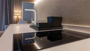 Ein modernes Hotelzimmer mit einem eleganten schwarzen Schreibtisch, einem Laptop und einer Ladestation.