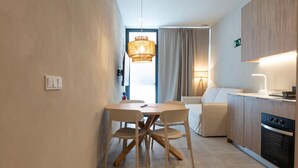 Eine moderne Küche mit Essbereich, einer Couch und einer Chandelier.