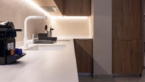 Eine moderne Küche mit weißem Arbeitsplatz, eingebauten Geräten und Holzschränken.