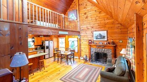 Ein gemütliches Blockhaus-Interieur mit Essbereich, Küche und Kamin.