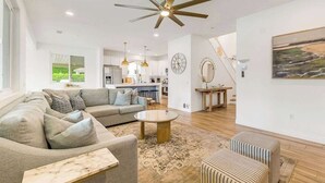 A spacious living room with a sofa, ottoman, coffee table, and a ceiling fan. - Catch The Magic- Pokémon Slide, Arcade, Pickleball (Indio)